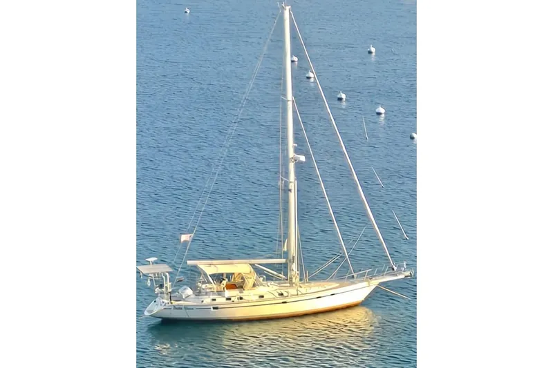 Peetee Hana Yacht Photos Pics 2008 Caliber center cockpit cutter sailboat anchored on calm blue water.