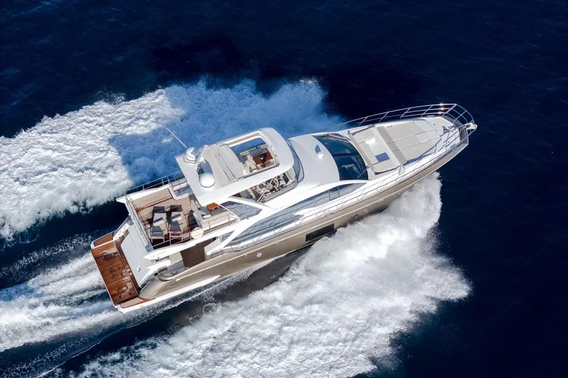 Ombretta V Yacht Photos Pics 2016 Azimut 66 yacht cruising on open water, aerial view.
