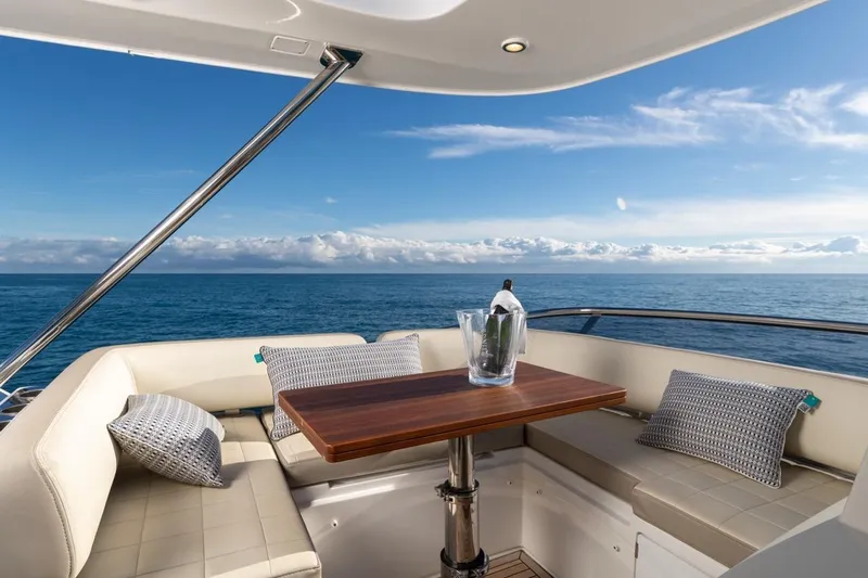 Ombretta V Yacht Photos Pics Luxurious 2016 Azimut 66 yacht deck with ocean view, featuring elegant seating and a wooden table.