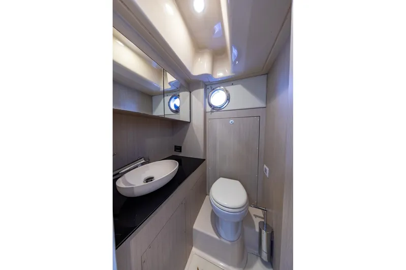 Ombretta V Yacht Photos Pics Luxurious bathroom in 2016 Azimut 66 yacht with modern fixtures and porthole window.