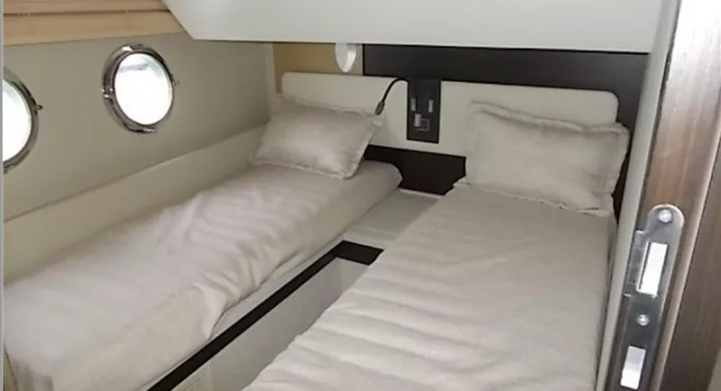 Ombretta Yacht Photos Pics Twin beds in a 2017 Azimut 66 yacht cabin with porthole windows.
