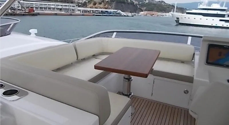 Ombretta Yacht Photos Pics Luxurious seating area on 2017 Azimut 66 yacht with wooden table and ocean view.