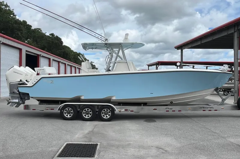  Yacht Photos Pics 2021 SeaVee 340Z boat on trailer, light blue hull, parked near storage units.