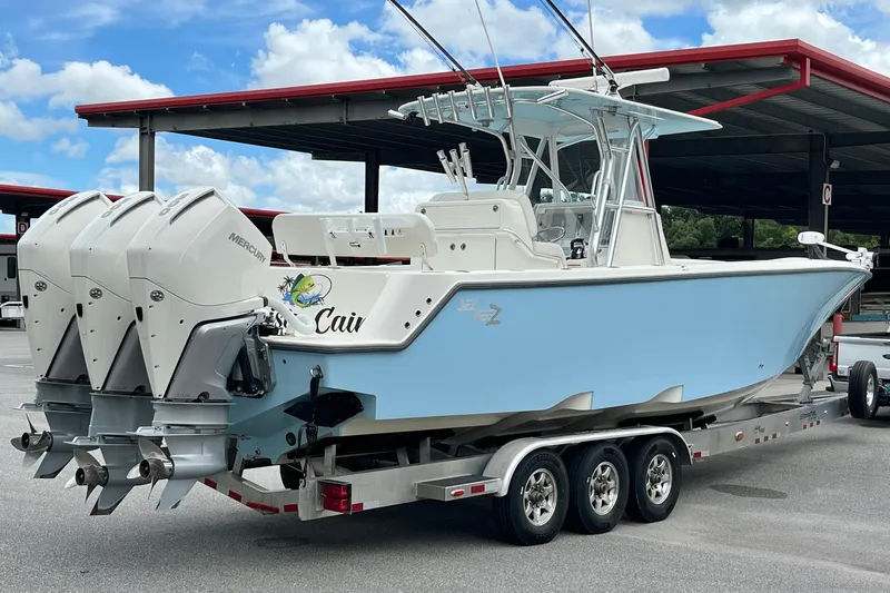  Yacht Photos Pics 2021 SeaVee 340Z boat with triple Mercury engines on a trailer, parked under a canopy.