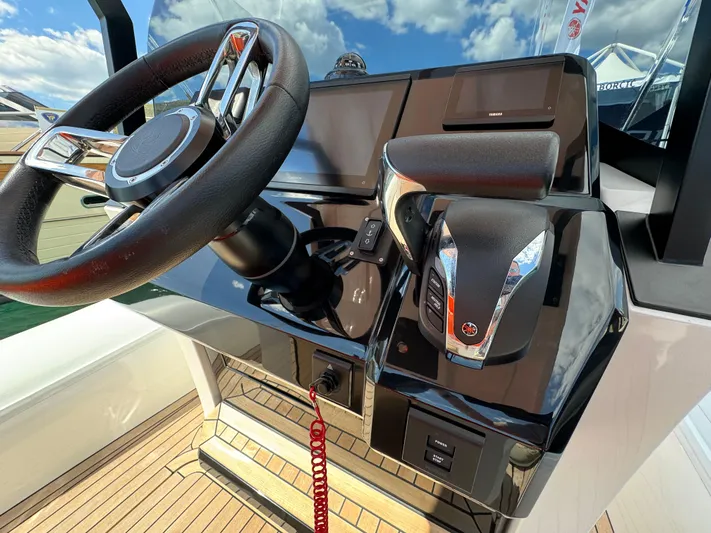  Yacht Photos Pics Control console of the 2025 SuperRib Open 27 boat with steering wheel and throttle.