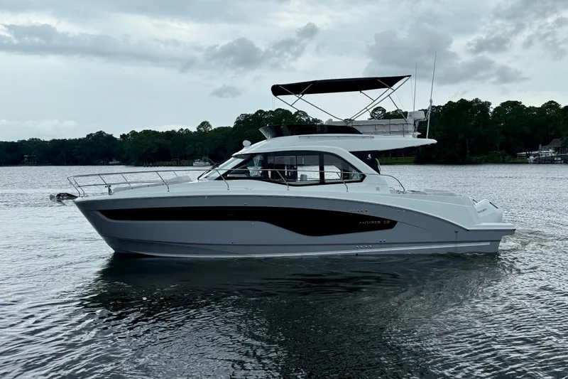  Yacht Photos Pics 2026 Beneteau Antares 12 yacht on a calm lake with overcast skies.