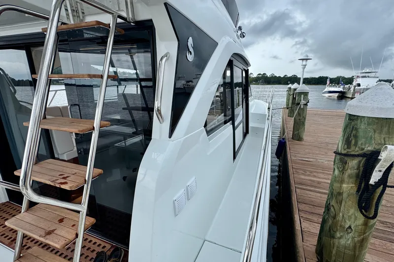  Yacht Photos Pics 2026 Beneteau Antares 12 docked, showcasing sleek design and wooden ladder steps.