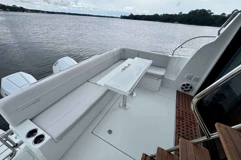  Yacht Photos Pics 2026 Beneteau Antares 12 boat deck with seating and table, overlooking calm waters.