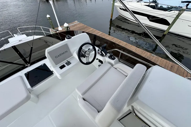  Yacht Photos Pics 2026 Beneteau Antares 12 yacht helm with Garmin navigation, docked by the water.
