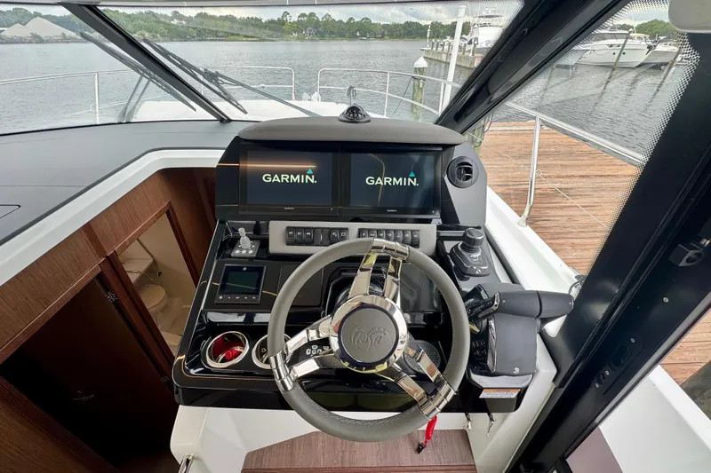 Yacht Photos Pics 2026 Beneteau Antares 12 helm with Garmin navigation system, docked by the water.