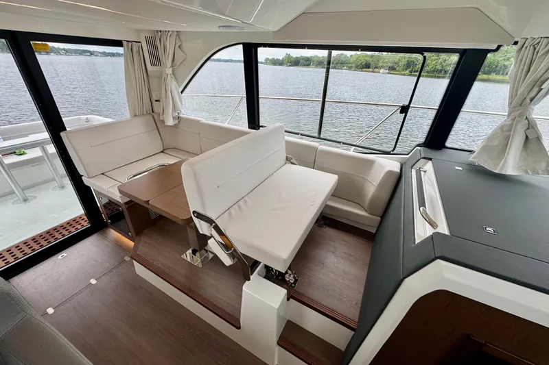  Yacht Photos Pics Interior of 2026 Beneteau Antares 12 yacht with elegant seating and scenic water view.