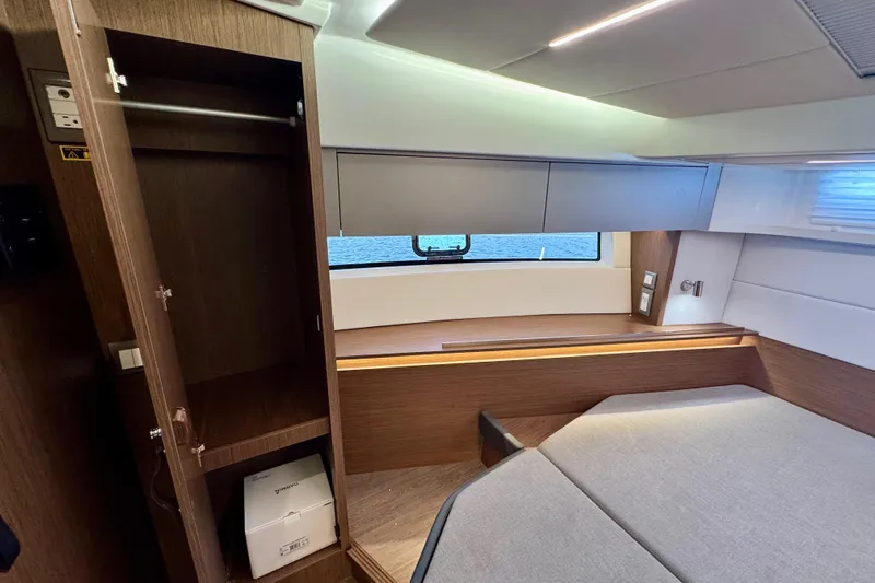  Yacht Photos Pics Interior of 2026 Beneteau Antares 12, featuring modern wood cabinetry and a cozy seating area.