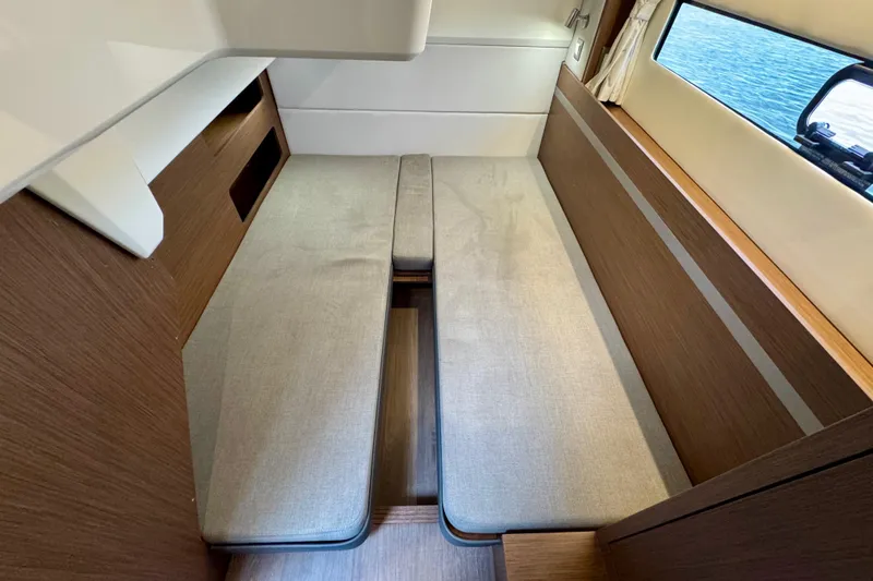  Yacht Photos Pics 2026 Beneteau Antares 12 cabin interior with wooden finish and cushioned seating.