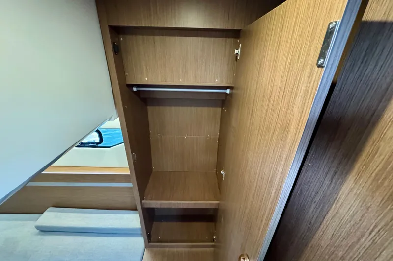  Yacht Photos Pics Interior view of 2026 Beneteau Antares 12 wooden closet with shelves.