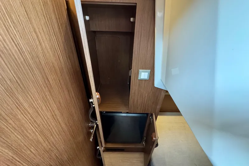  Yacht Photos Pics Interior storage space on 2026 Beneteau Antares 12 yacht, featuring wooden cabinetry.