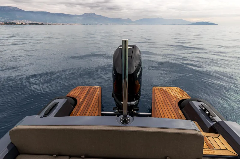  Yacht Photos Pics 2026 SuperRib Open 27 boat on calm water, featuring sleek design and wooden deck.