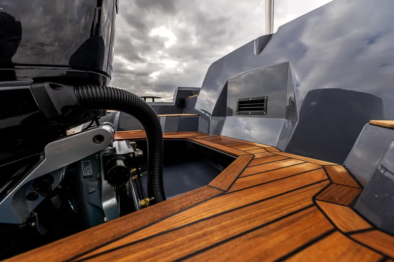  Yacht Photos Pics 2026 SuperRib Open 27 boat with sleek wooden deck and modern design under cloudy sky.