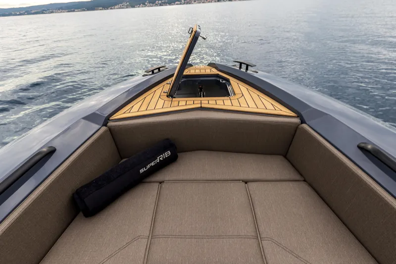  Yacht Photos Pics Bow view of 2026 SuperRib Open 27 boat with cushioned seating and open hatch.