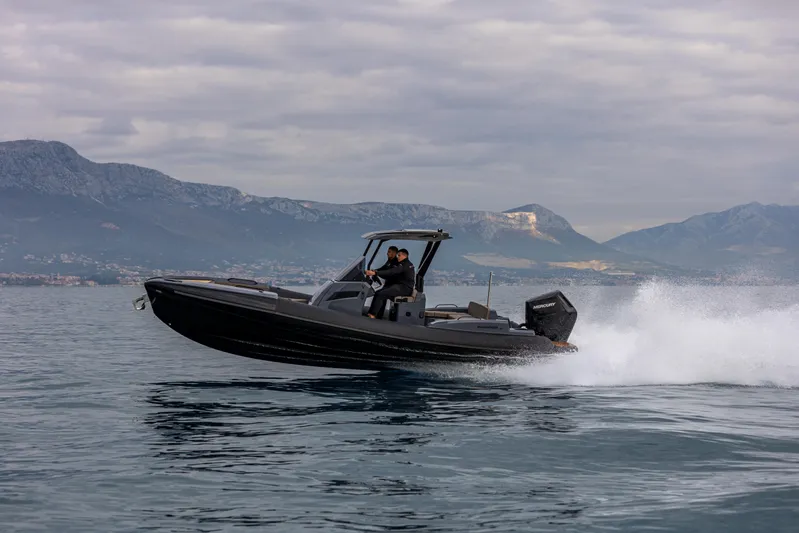  Yacht Photos Pics 2026 SuperRib Open 27 speeding on water with mountainous backdrop.