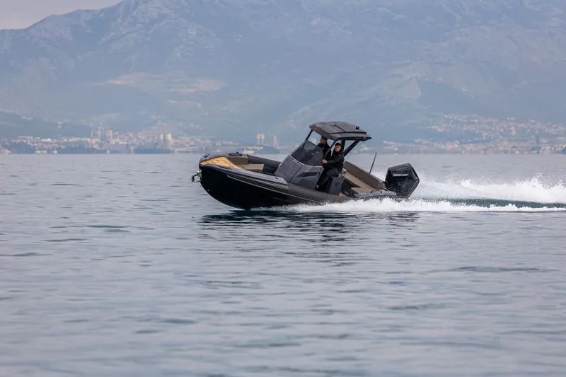  Yacht Photos Pics 2026 SuperRib Open 27 speeding on water with mountainous backdrop.