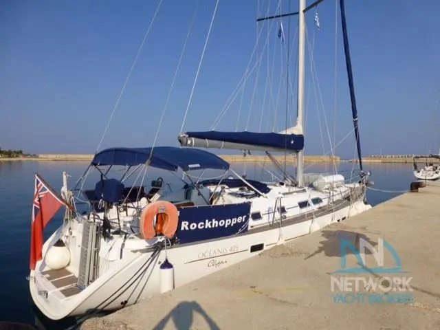  Yacht Photos Pics 2004 Beneteau Oceanis 423 sailboat docked, featuring blue canopy and "Rockhopper" name.