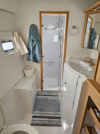 Moondance Yacht Photos Pics Interior of 2008 Lagoon 420 yacht bathroom with shower, sink, and nautical decor.