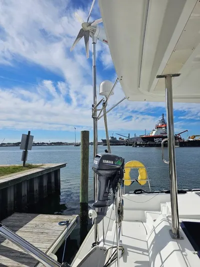Moondance Yacht Photos Pics 2008 Lagoon 420 catamaran docked, featuring Yamaha motor and wind turbine, under a clear blue sky.