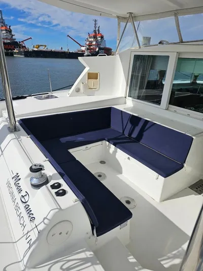 Moondance Yacht Photos Pics 2008 Lagoon 420 yacht with blue seating, docked near industrial ships.