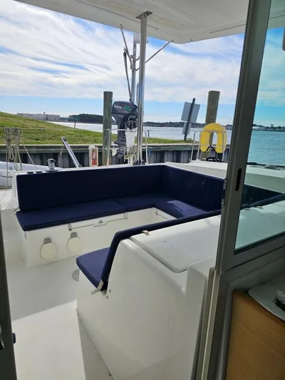 Moondance Yacht Photos Pics 2008 Lagoon 420 yacht with blue seating, docked by the water on a sunny day.