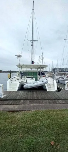 Moondance Yacht Photos Pics 2008 Lagoon 420 catamaran docked with dinghy, overcast sky, marina background.