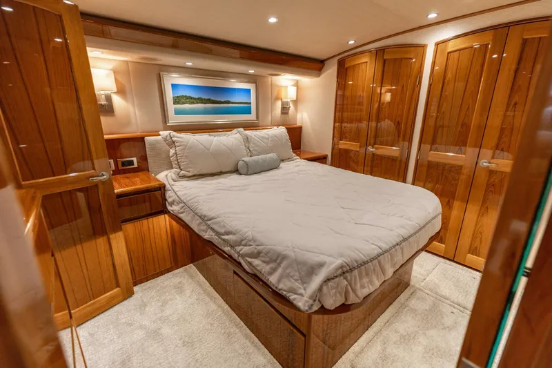 Gas Money Yacht Photos Pics Luxurious bedroom interior of 2015 Viking 62 Convertible yacht with wooden finishes.