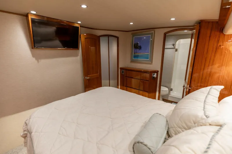 Gas Money Yacht Photos Pics Luxurious bedroom interior of 2015 Viking 62 Convertible yacht with ensuite bathroom and TV.