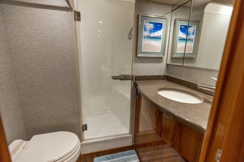 Gas Money Yacht Photos Pics Luxurious bathroom in 2015 Viking 62 Convertible yacht with modern fixtures and elegant decor.