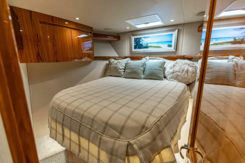 Gas Money Yacht Photos Pics Luxurious bedroom interior of 2015 Viking 62 Convertible yacht with plush bedding and elegant wood finishes.
