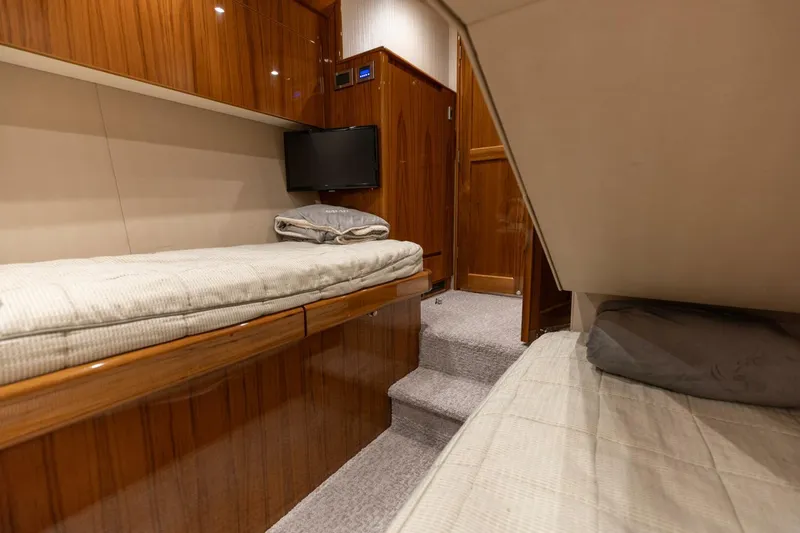 Gas Money Yacht Photos Pics Luxurious cabin interior of 2015 Viking 62 Convertible yacht with twin beds and TV.