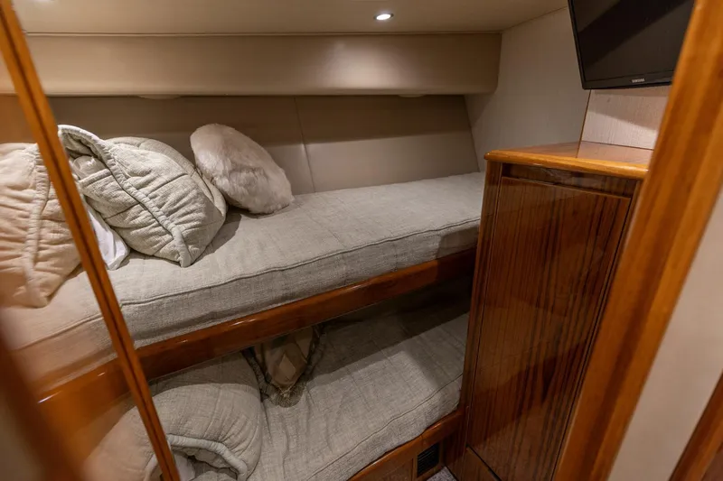 Gas Money Yacht Photos Pics Cozy cabin interior of 2015 Viking 62 Convertible yacht with bunk beds and wooden cabinetry.