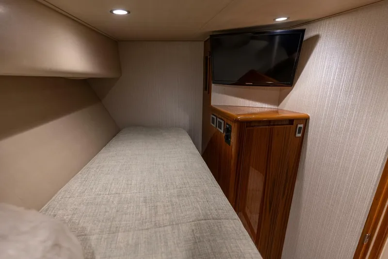 Gas Money Yacht Photos Pics 2015 Viking 62 Convertible cabin with bed, TV, and wooden cabinetry.