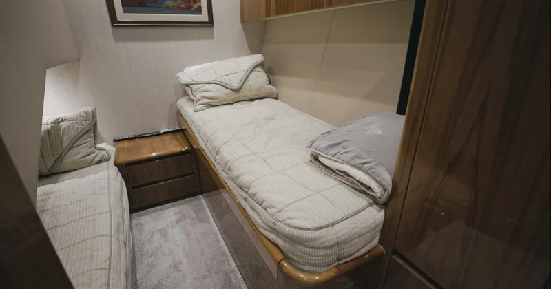 Gas Money Yacht Photos Pics Cozy cabin interior of 2015 Viking 62 Convertible yacht with twin beds and wooden furnishings.