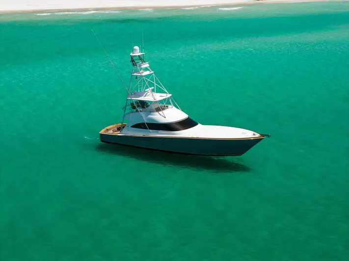 Gas Money Yacht Photos Pics 2015 Viking 62 Convertible yacht on turquoise water near sandy shore.