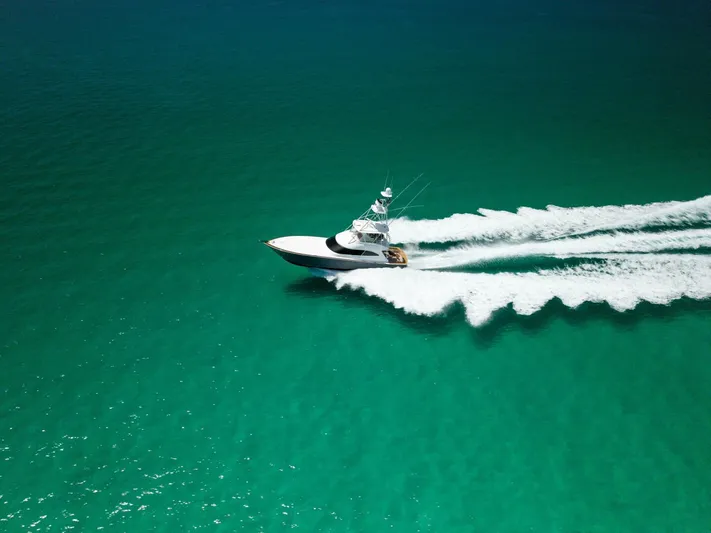 Gas Money Yacht Photos Pics 2015 Viking 62 Convertible yacht cruising on turquoise ocean waters.