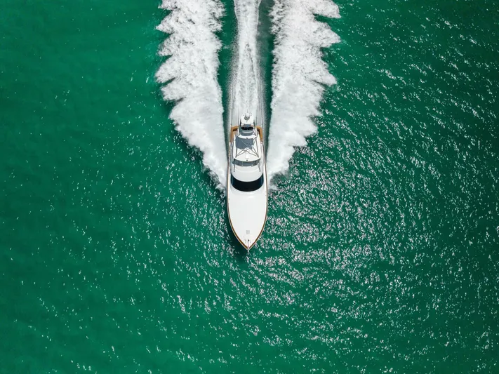 Gas Money Yacht Photos Pics Aerial view of 2015 Viking 62 Convertible yacht cruising on turquoise water.