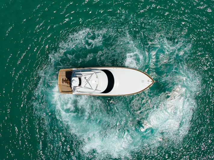 Gas Money Yacht Photos Pics Aerial view of 2015 Viking 62 Convertible yacht navigating turquoise waters.
