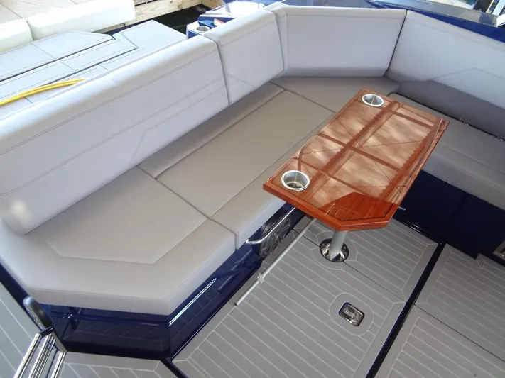  Yacht Photos Pics 2021 Cruisers Yachts 38 GLS I/O interior with cushioned seating and wooden table.