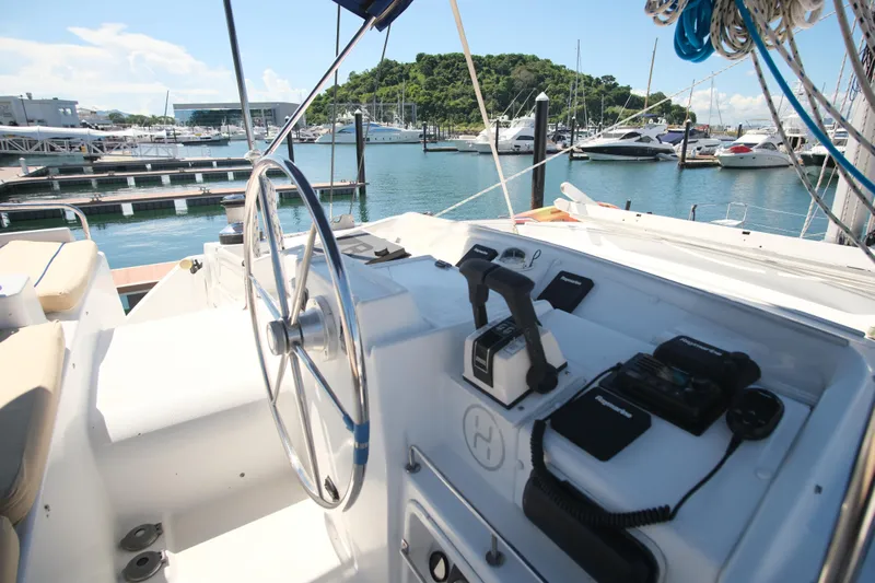 Sv Hypnautic Yacht Photos Pics Cockpit of 2002 Lagoon 440 catamaran at marina, featuring steering wheel and navigation equipment.