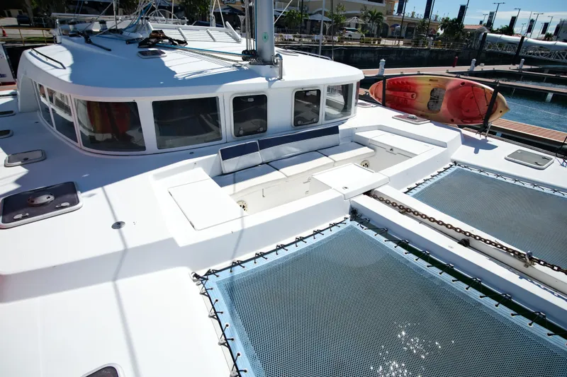 Sv Hypnautic Yacht Photos Pics 2002 Lagoon 440 catamaran deck with seating and netting, docked at marina.