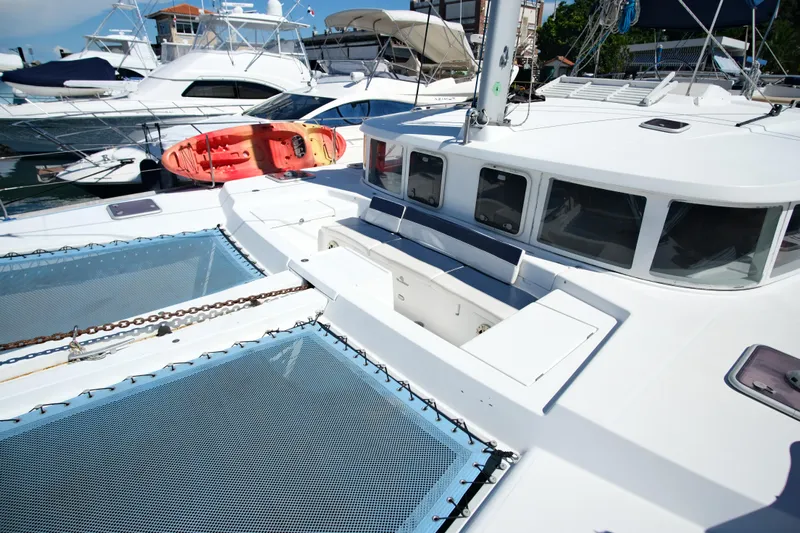 Sv Hypnautic Yacht Photos Pics 2002 Lagoon 440 catamaran with spacious deck and kayak, docked at marina.