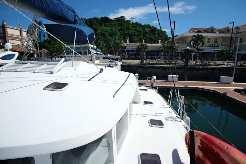Sv Hypnautic Yacht Photos Pics Lagoon 440 catamaran docked at marina, sunny day, lush greenery in background.