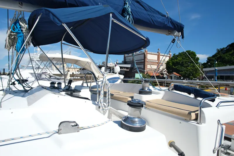 Sv Hypnautic Yacht Photos Pics 2002 Lagoon 440 yacht deck with blue canopy and seating, docked under clear skies.