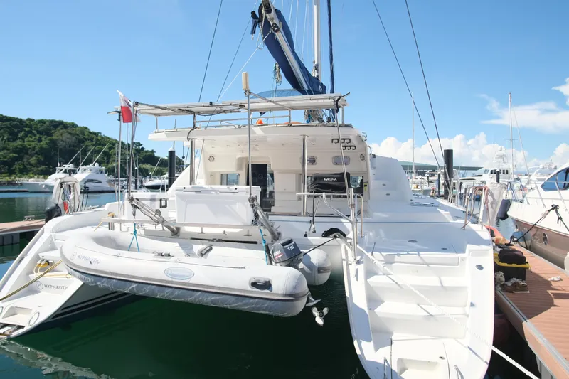 Sv Hypnautic Yacht Photos Pics 2002 Lagoon 440 catamaran docked at marina with inflatable dinghy.
