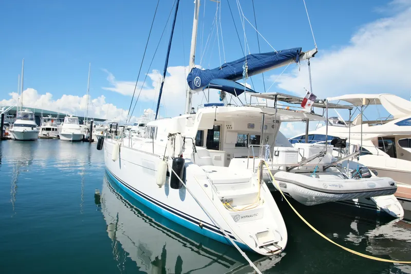 Sv Hypnautic Yacht Photos Pics 2002 Lagoon 440 catamaran docked in a marina under a clear blue sky.